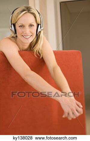 Stock Photo - Young woman listening to music with headphones. Fotosearch