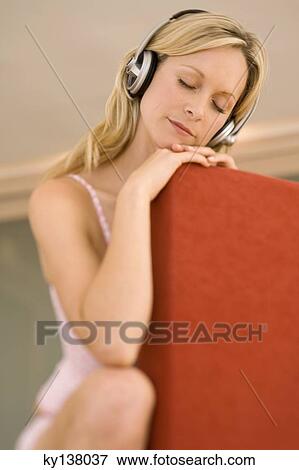 Young woman listening to music with headphones View Large Photo Image Stock Photo - Young woman listening to music with headphones. Fotosearch