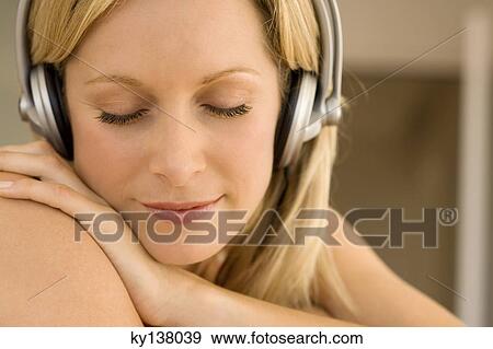 Young woman listening to music with headphones View Large Photo Image Stock Photo - Young woman listening to music with headphones. Fotosearch