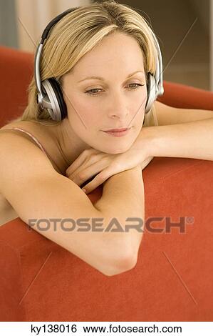 Stock Photograph - Young woman listening to music with headphones. Fotosearch