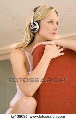 Stock Photography - Young woman listening to music with headphones. Fotosearch