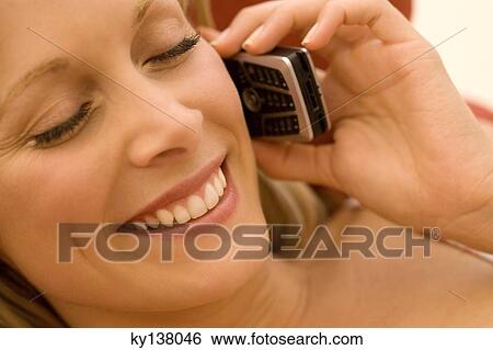 Stock Photograph - Young woman using mobile phone. Fotosearch