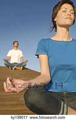 Couple in yoga attitude, outdoors View Large Photo Image Stock Photo - Couple in yoga attitude, outdoors. Fotosearch