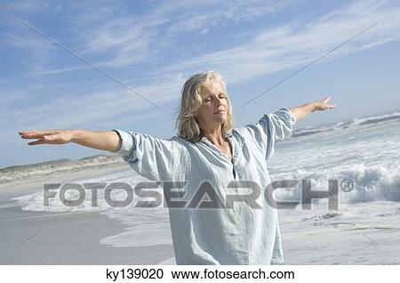 Stock Image - Woman in yoga attitude on the beach, outdoors. Fotosearch