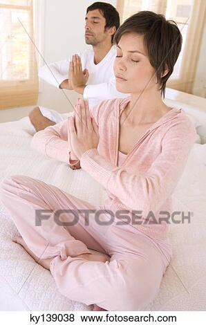 Young couple in yoga attitude, indoors View Large Photo Image Stock Photo - Young couple in yoga attitude, indoors. Fotosearch