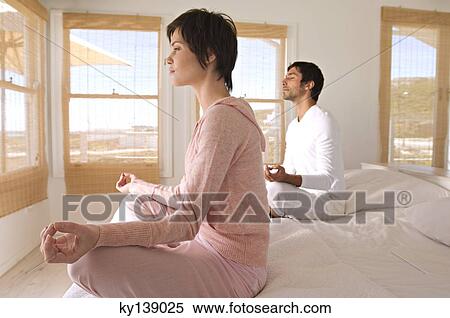Young couple in yoga attitude, indoors View Large Photo Image Stock Photography - Young couple in yoga attitude, indoors. Fotosearch