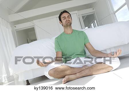 Young man in yoga attitude, indoors View Large Photo Image Stock Photograph - Young man in yoga attitude, indoors. Fotosearch