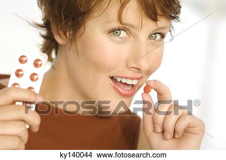 Portrait of a young smiling woman holding pills View Large Photo Image Picture - Portrait of a young smiling woman holding pills. Fotosearch