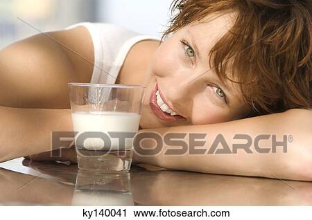 Portrait of a young smiling woman, glass of milk View Large Photo Image Stock Image - Portrait of a young smiling woman, glass of milk. Fotosearch