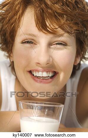 Portrait of a young smiling woman, glass of milk View Large Photo Image Stock Photo - Portrait of a young smiling woman, glass of milk. Fotosearch