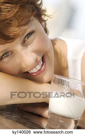 Portrait of a young smiling woman, glass of milk View Large Photo Image Stock Photograph - Portrait of a young smiling woman, glass of milk. Fotosearch