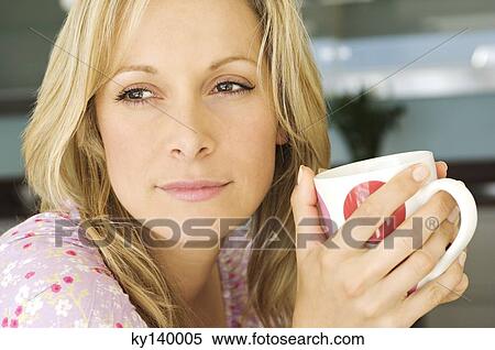 Portrait of a young thinking woman, holding mug View Large Photo Image Stock Photography - Portrait of a young thinking woman, holding mug. Fotosearch