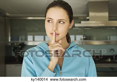 Portrait of a young woman, finger on lips View Large Photo Image Picture - Portrait of a young woman, finger on lips. Fotosearch