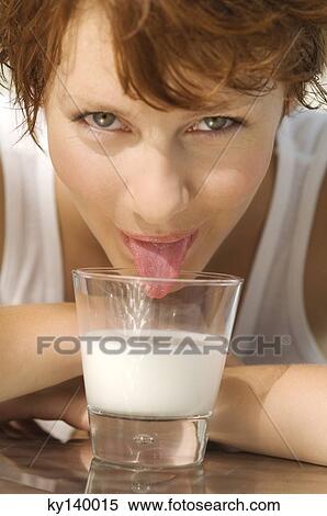 Portrait of a young woman licking milk from a glass View Large Photo Image Stock Photography - Portrait of a young woman licking milk from a glass. Fotosearch