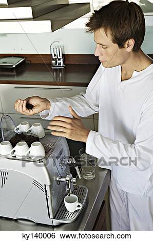 Young man using coffee maker View Large Photo Image Stock Photograph - Young man using coffee maker. Fotosearch
