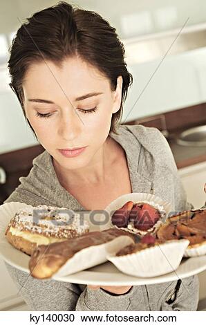 Young woman holding cakes View Large Photo Image Stock Image - Young woman holding cakes. Fotosearch