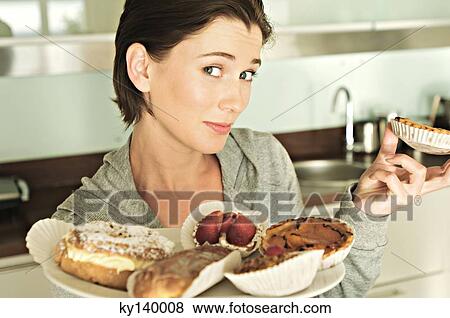 Young woman holding cakes View Large Photo Image Stock Photo - Young woman holding cakes. Fotosearch