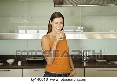 Young woman holding glass of orange juice View Large Photo Image Stock Photograph - Young woman holding glass of orange juice. Fotosearch