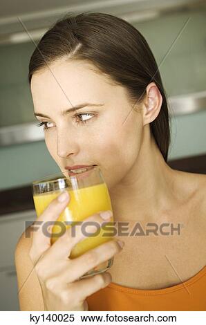 Young woman holding glass of orange juice View Large Photo Image Stock Photography - Young woman holding glass of orange juice. Fotosearch