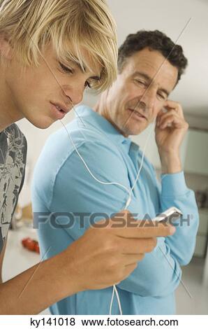 Man and teen boy sharing MP3 player View Large Photo Image Stock Photo - Man and teen boy sharing MP3 player. Fotosearch