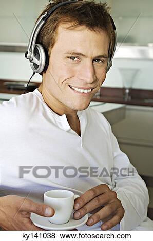 Portrait of a young man listening to music with headphones View Large Photo Image Stock Photo - Portrait of a young man listening to music with headphones. Fotosearch