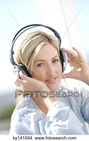 Portrait of a young woman, listening to music with headphones View Large Photo Image Picture - Portrait of a young woman, listening to music with headphones. Fotosearch