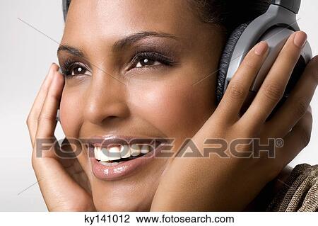 Portrait of a young woman, listening to music with headphones View Large Photo Image Stock Image - Portrait of a young woman, listening to music with headphones. Fotosearch