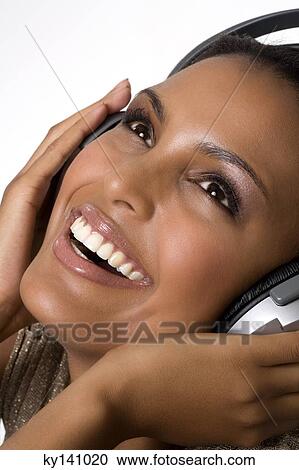 Portrait of a young woman, listening to music with headphones View Large Photo Image Stock Image - Portrait of a young woman, listening to music with headphones. Fotosearch