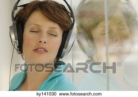 Portrait of a young woman, listening to music with headphones View Large Photo Image Stock Image - Portrait of a young woman, listening to music with headphones. Fotosearch