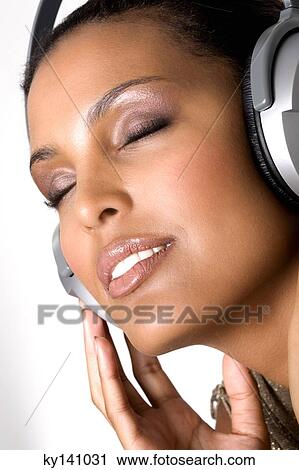 Portrait of a young woman, listening to music with headphones View Large Photo Image Stock Image - Portrait of a young woman, listening to music with headphones. Fotosearch