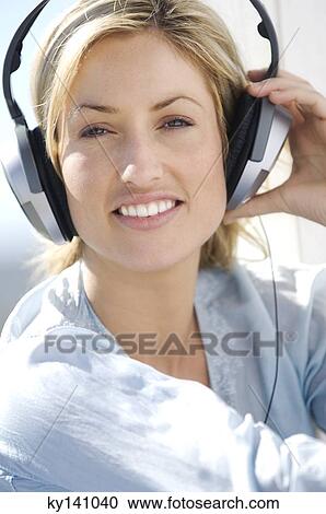Portrait of a young woman, listening to music with headphones View Large Photo Image Stock Image - Portrait of a young woman, listening to music with headphones. Fotosearch