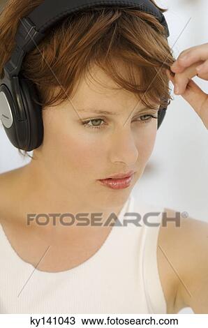 Portrait of a young woman, listening to music with headphones View Large Photo Image Stock Image - Portrait of a young woman, listening to music with headphones. Fotosearch
