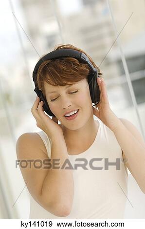 Portrait of a young woman, listening to music with headphones View Large Photo Image Stock Photo - Portrait of a young woman, listening to music with headphones. Fotosearch