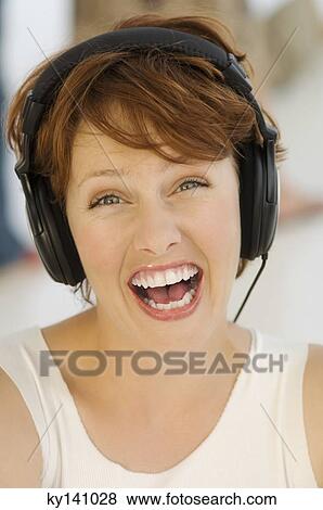 Portrait of a young woman, listening to music with headphones View Large Photo Image Stock Photo - Portrait of a young woman, listening to music with headphones. Fotosearch