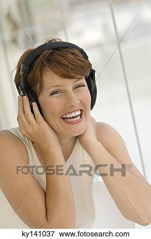 Portrait of a young woman, listening to music with headphones View Large Photo Image Stock Photo - Portrait of a young woman, listening to music with headphones. Fotosearch