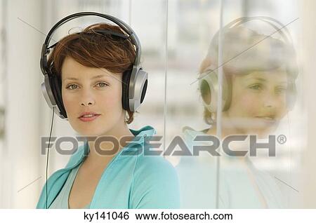 Portrait of a young woman, listening to music with headphones View Large Photo Image Stock Photograph - Portrait of a young woman, listening to music with headphones. Fotosearch