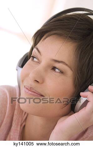 Portrait of a young woman, listening to music with headphones View Large Photo Image Stock Photography - Portrait of a young woman, listening to music with headphones. Fotosearch
