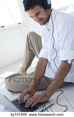 Young man using laptop View Large Photo Image Stock Photo - Young man using laptop. Fotosearch
