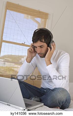 Young man using laptop View Large Photo Image Stock Photograph - Young man using laptop. Fotosearch
