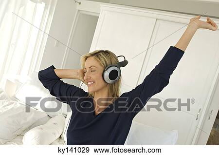 Young woman listening to music with headphones View Large Photo Image Stock Photo - Young woman listening to music with headphones. Fotosearch