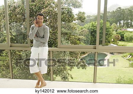 Man phoning, leaning against bay window View Large Photo Image Stock Image - Man phoning, leaning against bay window. Fotosearch