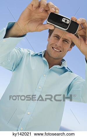 Portrait of a man using camera phone View Large Photo Image Stock Image - Portrait of a man using camera phone. Fotosearch