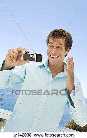 Portrait of a man using camera phone View Large Photo Image Stock Photo - Portrait of a man using camera phone. Fotosearch