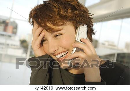 Portrait of a smiling woman phoning View Large Photo Image Stock Photo - Portrait of a smiling woman phoning. Fotosearch