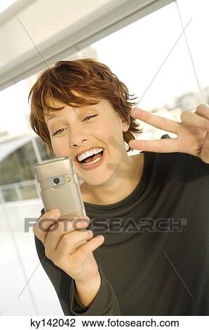 Portrait of a smiling woman using camera phone View Large Photo Image Stock Image - Portrait of a smiling woman using camera phone. Fotosearch