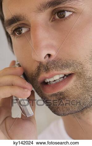 Picture - Portrait of a young man using mobile phone. Fotosearch