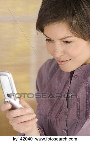 Portrait of a young woman using mobile phone View Large Photo Image Stock Image - Portrait of a young woman using mobile phone. Fotosearch