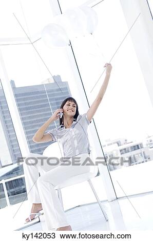 Smiling woman phoning, holding white balloons View Large Photo Image Stock Image - Smiling woman phoning, holding white balloons. Fotosearch
