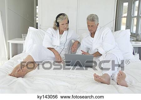 Stock Photograph - Couple using laptop in bed. Fotosearch