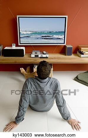 Man watching TV sitting on floor View Large Photo Image Stock Image - Man watching TV sitting on floor. Fotosearch